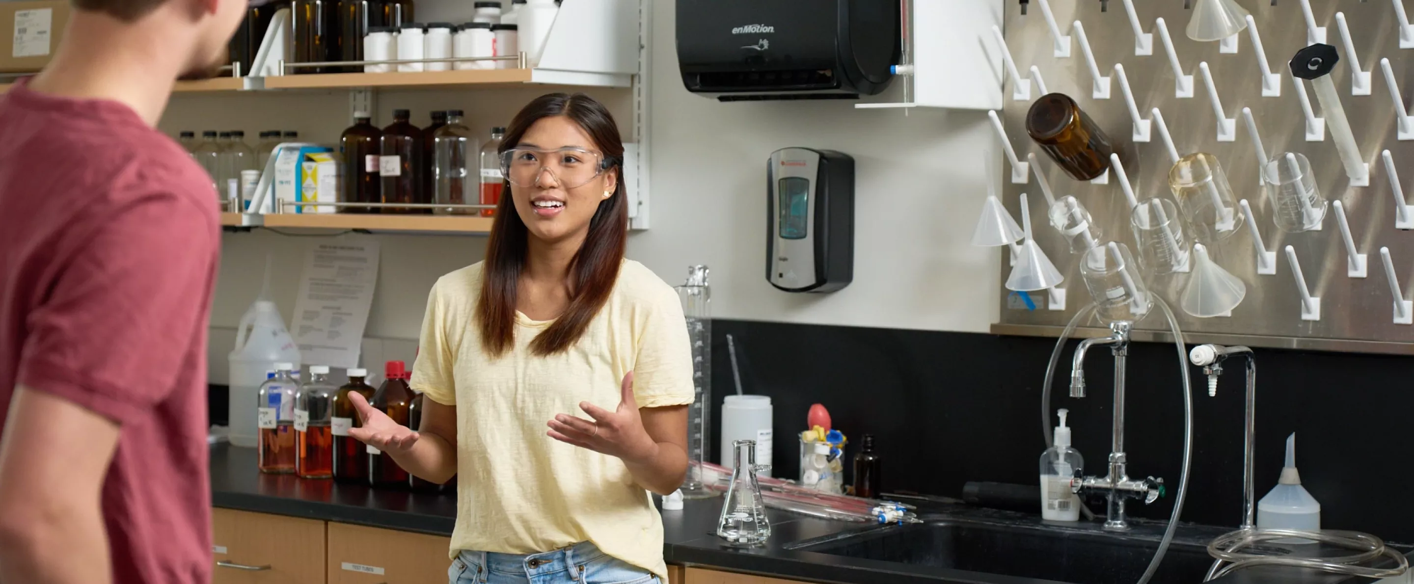 Two students having a discussion in a chemistry laboratory