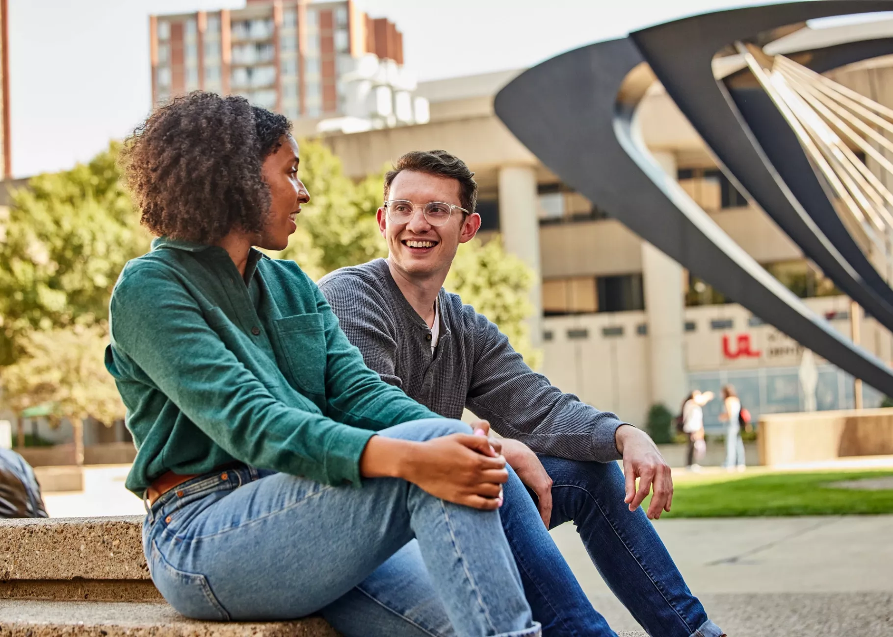 Two students have a pleasant conversation with each other in the HSC courtyard.