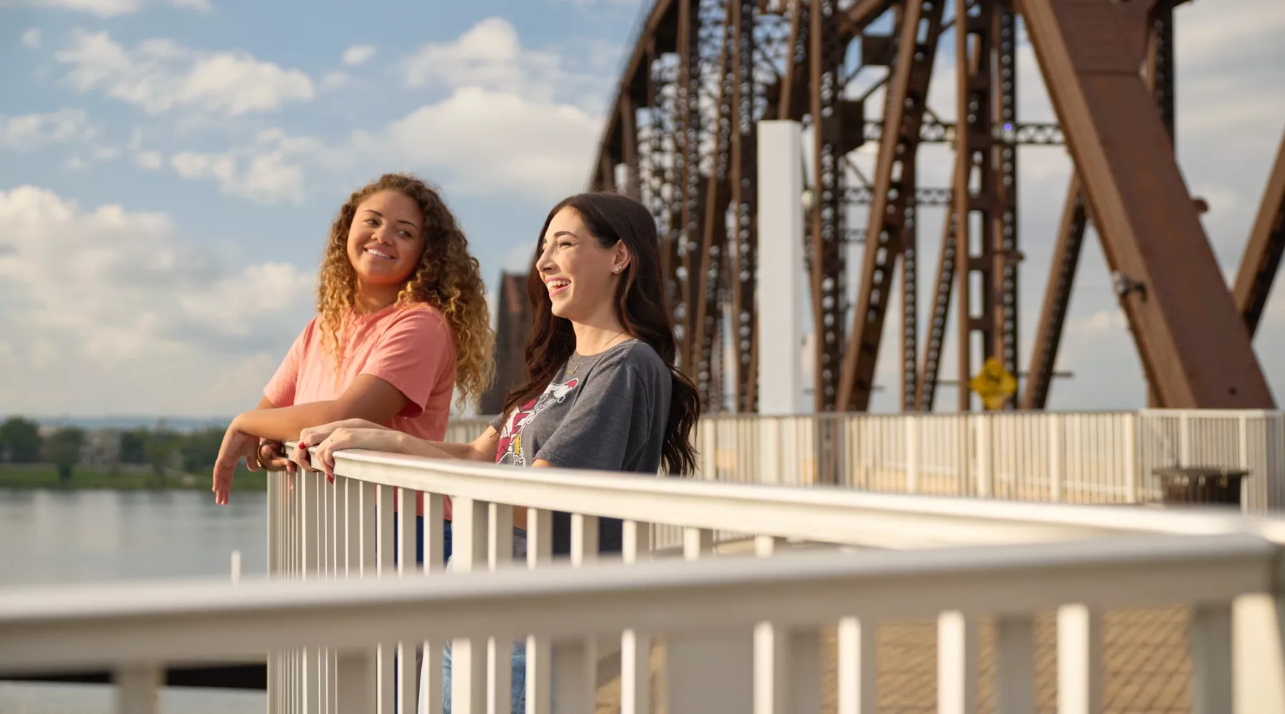 Two students looking at the skyline on the bridge.