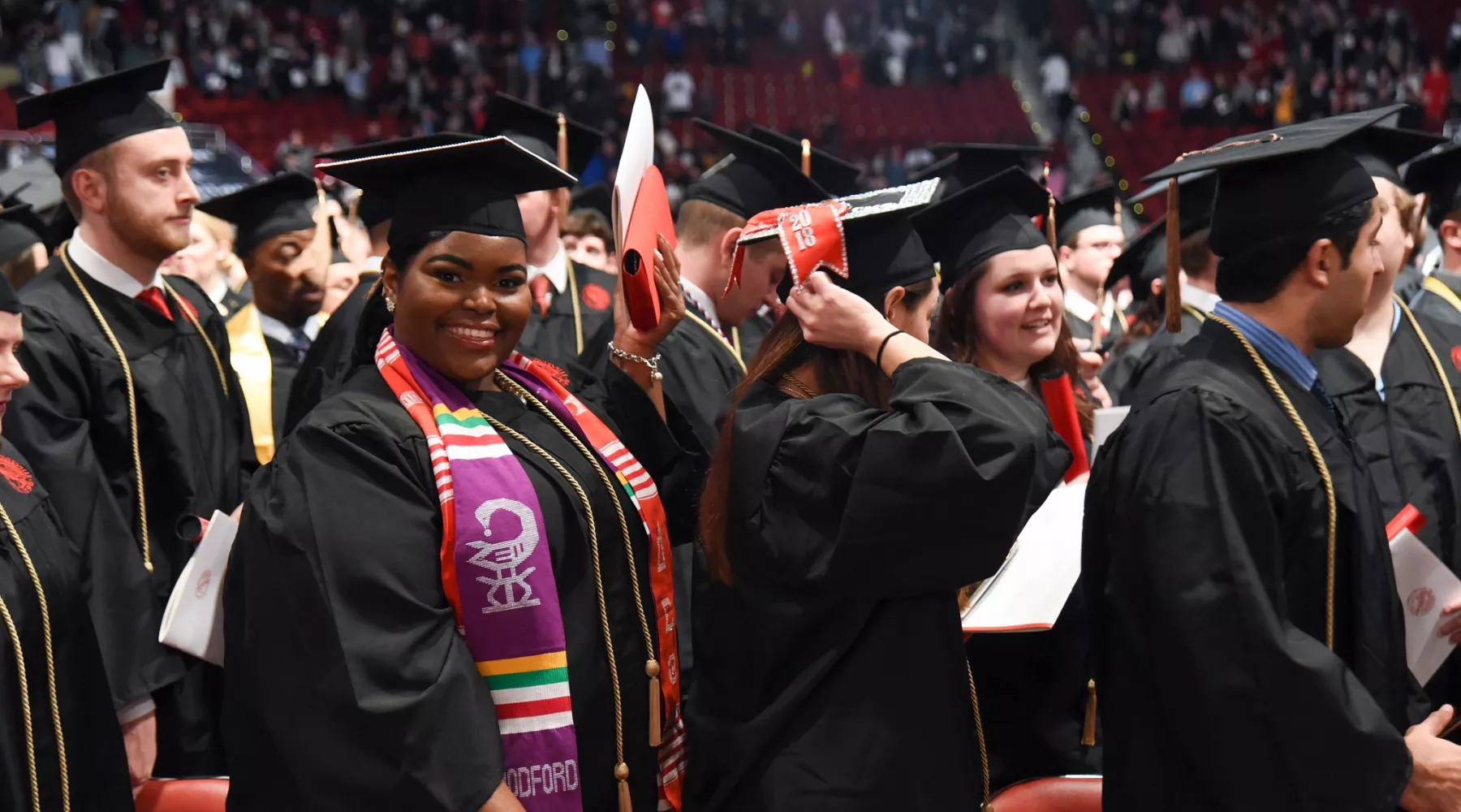 Student at commencement smiling and looking at the camera