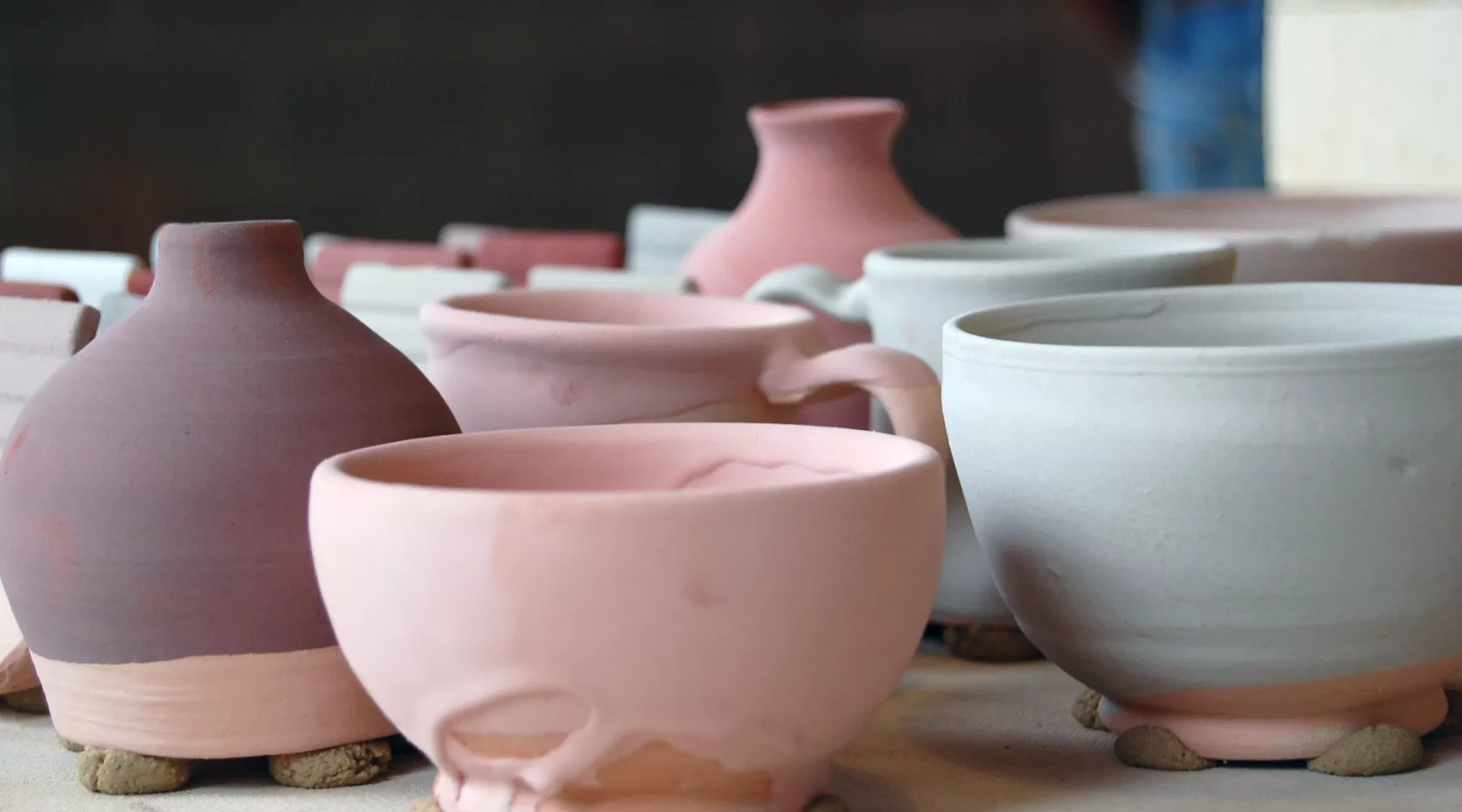 An assortment of glazed, unfired pottery waiting for the kiln