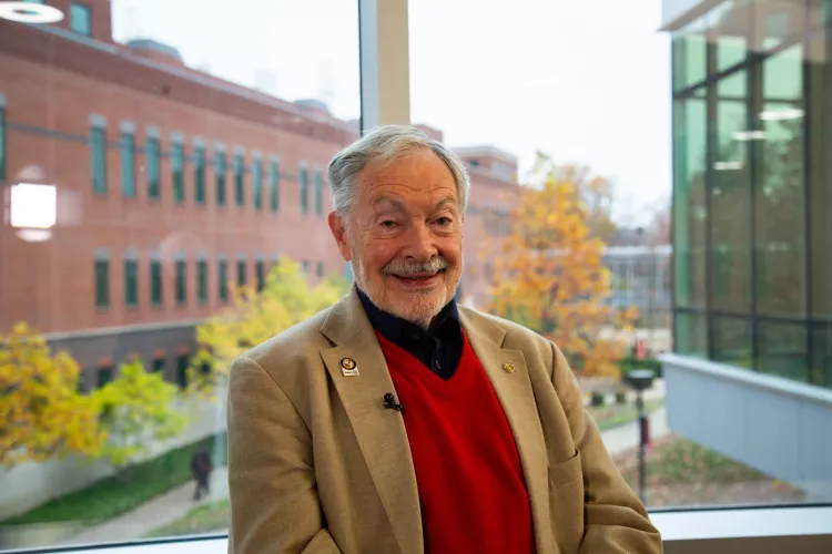 Man in red vest inside UofL building