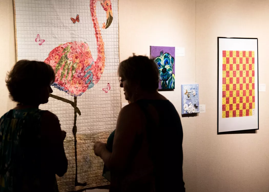 Two woman discuss artwork at the Open Walls Exhibit