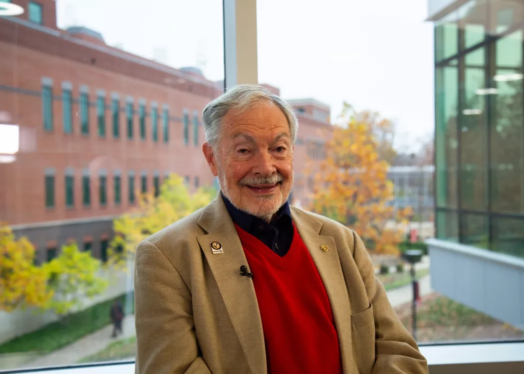 Man in red vest inside UofL building