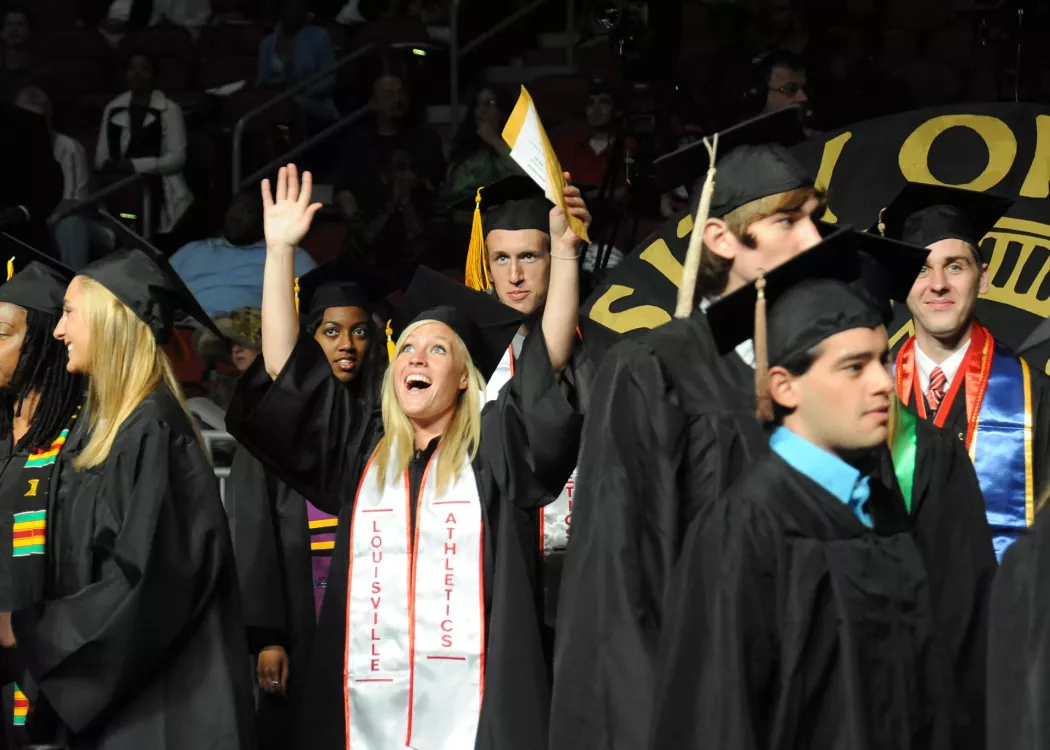 Graduate throws her hands in celebration at graduation