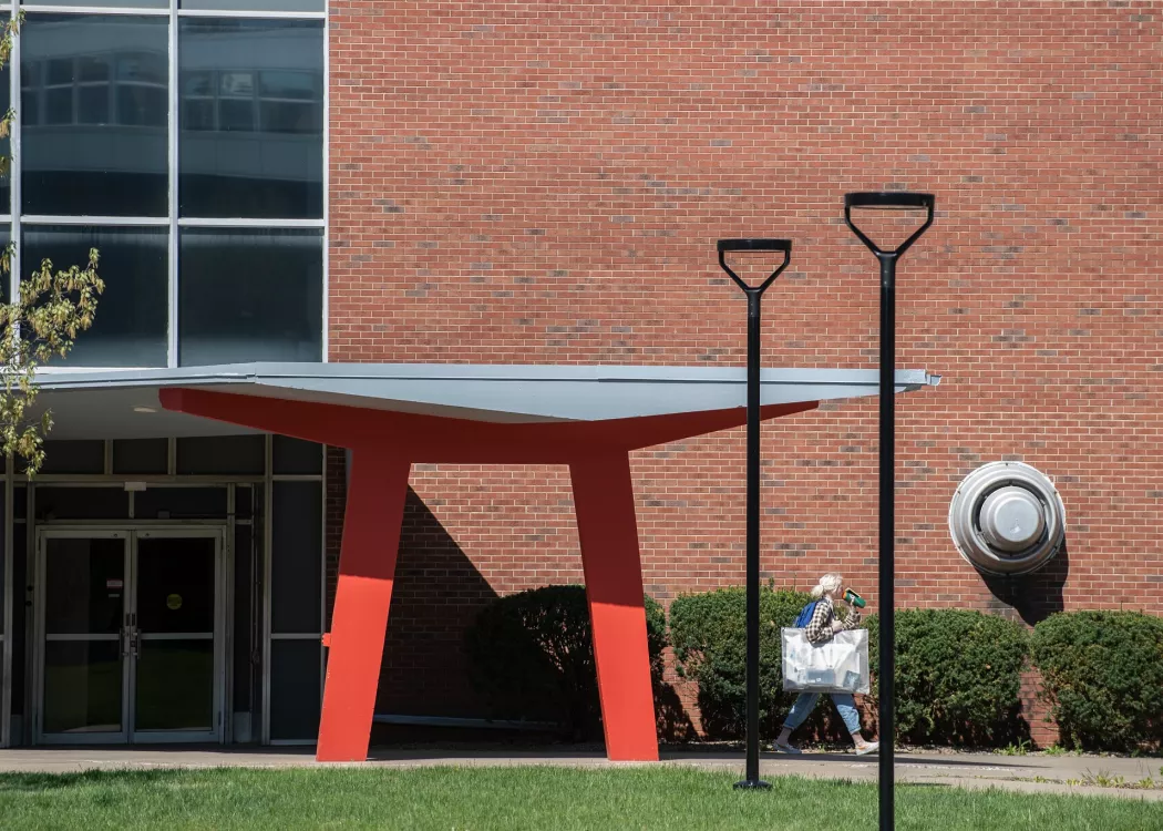 Student walking under Schneider Hall.