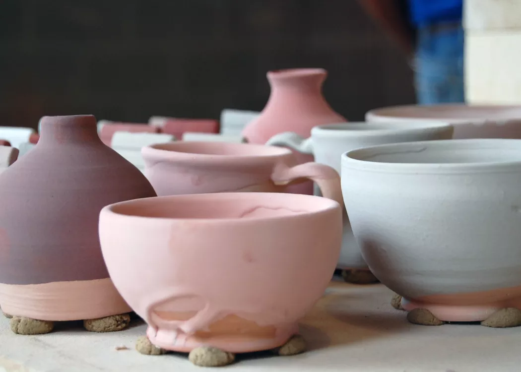 An assortment of glazed, unfired pottery waiting for the kiln