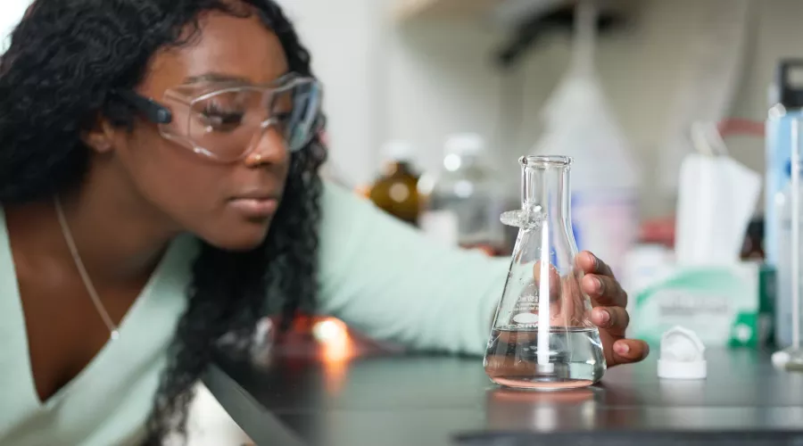 Female student performs chemistry experiment in a lab