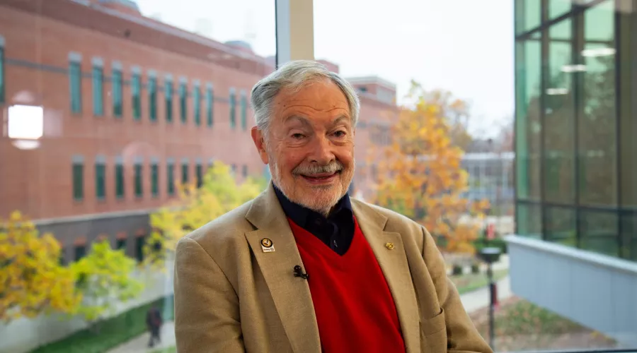 Man in red vest inside UofL building